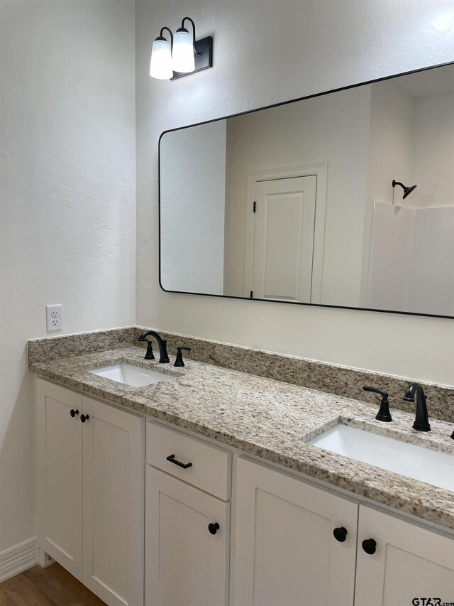 bathroom featuring a shower, wood-type flooring, and vanity