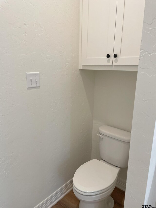 bathroom with toilet and wood-type flooring