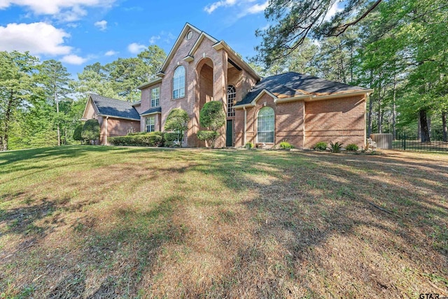 18050 Deer Trl, Flint, TX 75762 - view of front of house featuring central air condition unit, a front yard, fence, and brick siding