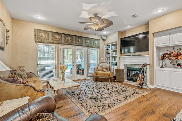 18050 Deer Trl, Flint, TX 75762 - living room featuring built in shelves, recessed lighting, a fireplace, a ceiling fan, and wood-type flooring