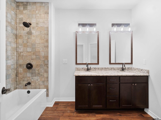 bathroom featuring tiled shower / bath combo, wood-type flooring, and vanity