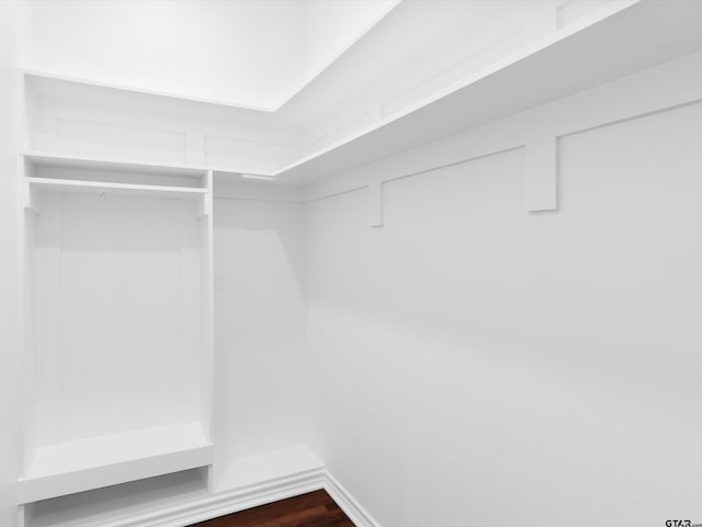 walk in closet with dark wood-type flooring