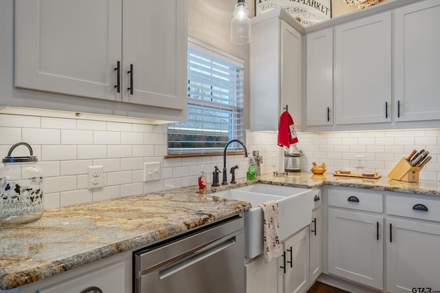 kitchen featuring backsplash, light stone countertops, dishwasher, and white cabinets