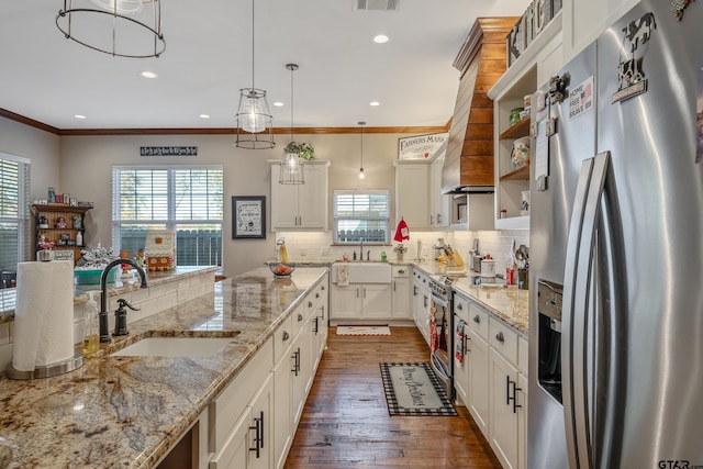 kitchen with appliances with stainless steel finishes, dark hardwood / wood-style flooring, sink, decorative light fixtures, and white cabinetry