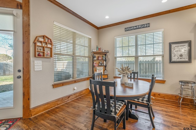 dining room with hardwood / wood-style floors and crown molding