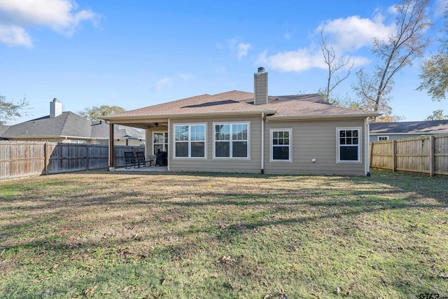 rear view of house with a patio area, ceiling fan, and a yard