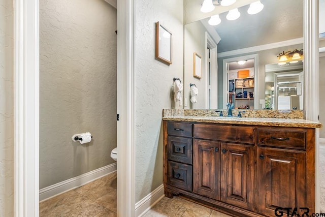 bathroom with a textured wall and tile patterned floors