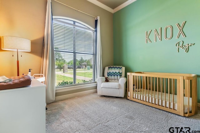 bedroom with a nursery area, carpet, crown molding, and baseboards