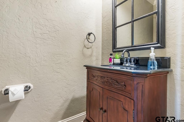 bathroom featuring a textured wall and vanity