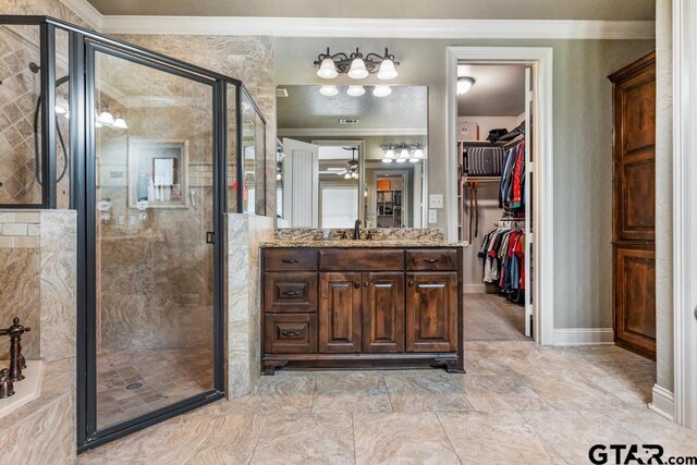 bathroom featuring vanity, a spacious closet, a shower stall, and ornamental molding