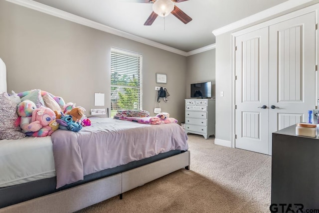 carpeted bedroom with ceiling fan, a closet, baseboards, and ornamental molding