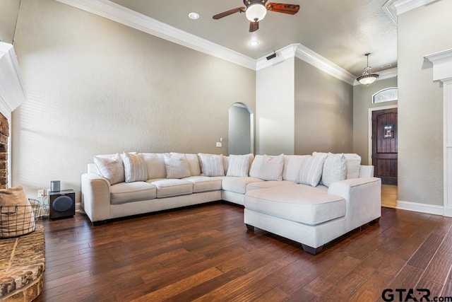 living room with a ceiling fan, crown molding, hardwood / wood-style floors, arched walkways, and baseboards