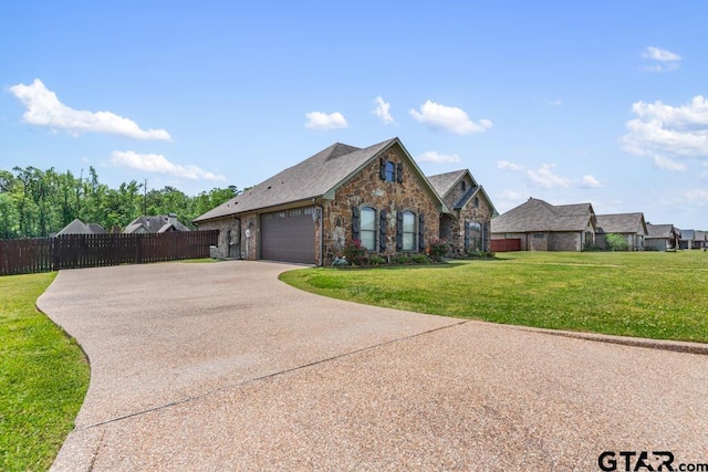 view of front of house with an attached garage, a front lawn, concrete driveway, and fence