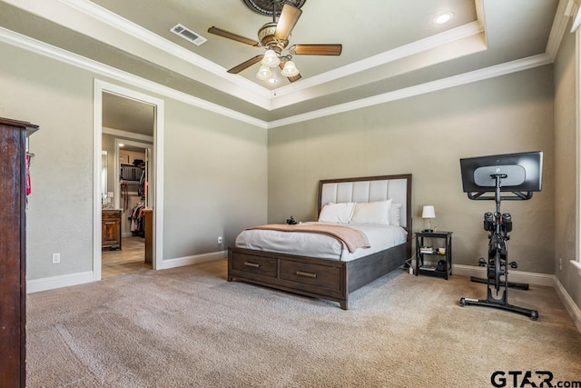 carpeted bedroom featuring a tray ceiling, visible vents, a ceiling fan, ornamental molding, and baseboards