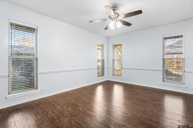 empty room with dark hardwood / wood-style floors, ceiling fan, and a wealth of natural light