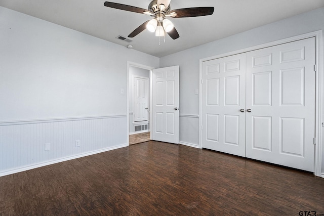 unfurnished bedroom with ceiling fan, a closet, and dark hardwood / wood-style floors