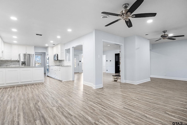 unfurnished living room featuring light wood-type flooring and ceiling fan