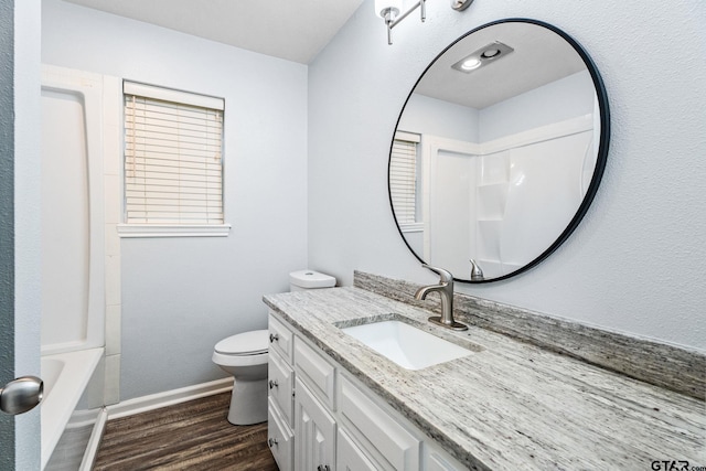 full bathroom with bathing tub / shower combination, vanity, wood-type flooring, and toilet