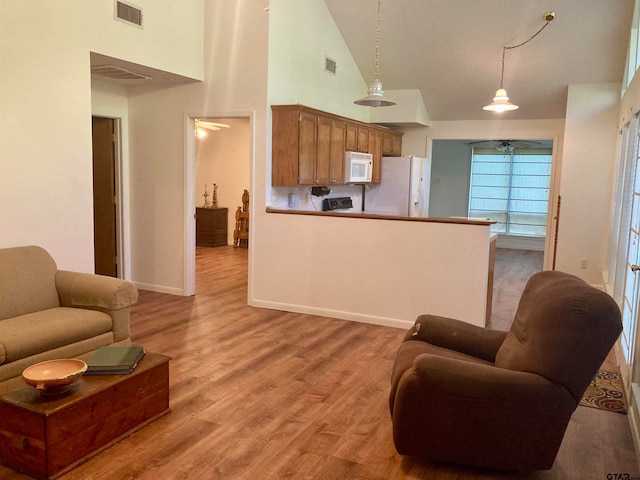 living room with high vaulted ceiling and light wood-type flooring