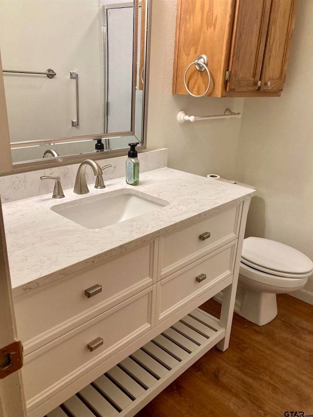 bathroom featuring toilet, vanity, and hardwood / wood-style flooring