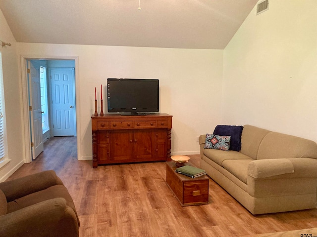 living room featuring light hardwood / wood-style floors and lofted ceiling