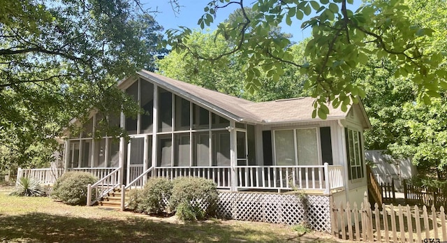371 Wildwood Trl, Holly Lake Ranch, TX 75765 - back of property with a sunroom and a shingled roof