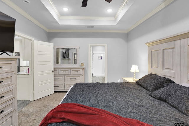 bedroom with ceiling fan, carpet floors, a tray ceiling, ornamental molding, and visible vents