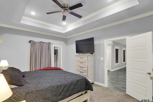 carpeted bedroom with recessed lighting, a raised ceiling, a ceiling fan, ornamental molding, and baseboards