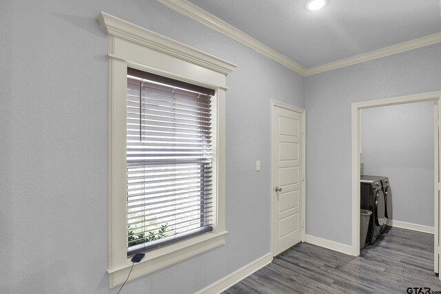 interior space with wood finished floors, crown molding, baseboards, and separate washer and dryer