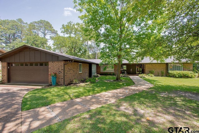 225 Texas Dr, Hideaway, TX 75771 - ranch-style house with brick siding, an attached garage, a front lawn, and driveway