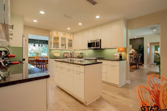 225 Texas Dr, Hideaway, TX 75771 - kitchen with appliances with stainless steel finishes, light wood finished floors, decorative backsplash, white cabinetry, and recessed lighting