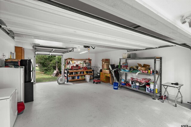 garage with a garage door opener and freestanding refrigerator