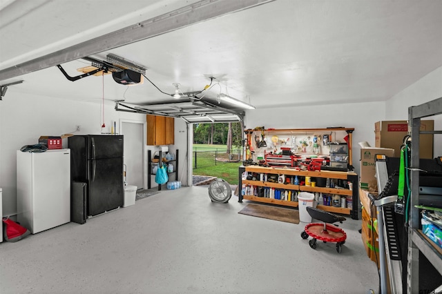 garage with freestanding refrigerator, a workshop area, and a garage door opener