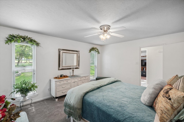 bedroom with ceiling fan, carpet flooring, multiple windows, and a textured ceiling