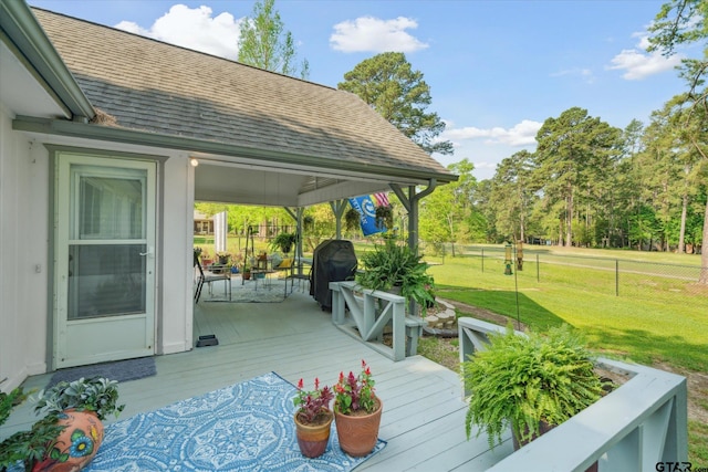 deck featuring grilling area, a yard, and fence