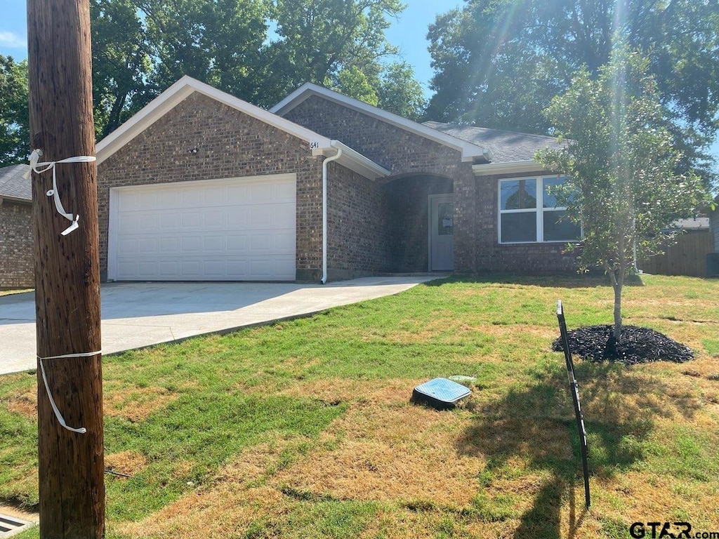 single story home with a garage and a front yard