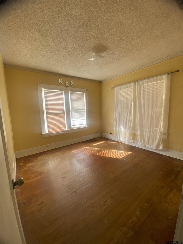 spare room with hardwood / wood-style flooring and a textured ceiling