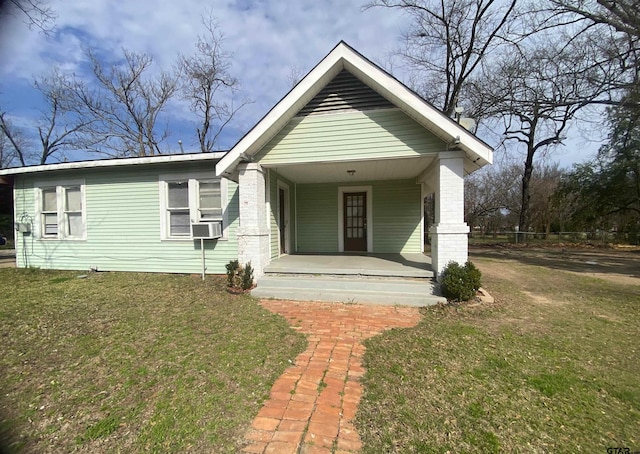 view of front of property featuring cooling unit, covered porch, and a front lawn