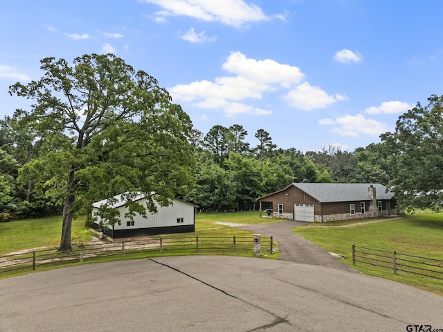 exterior space with a rural view, an outbuilding, and a front lawn