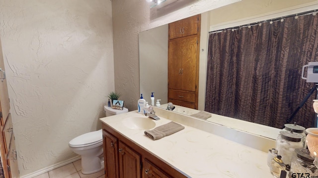 bathroom with tile patterned flooring, vanity, and toilet