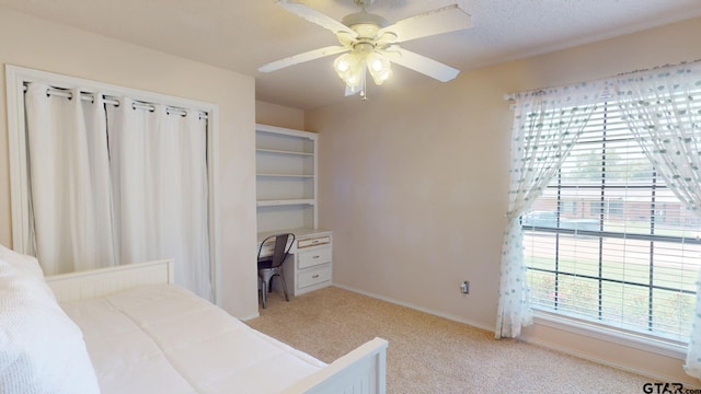 bedroom with ceiling fan, multiple windows, and light colored carpet