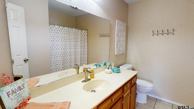 bathroom featuring vanity, tile patterned flooring, and toilet