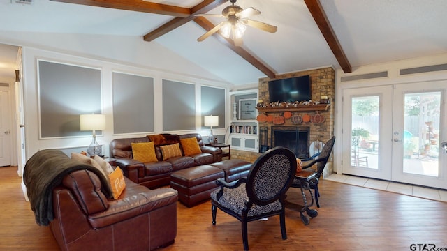 living room featuring a stone fireplace, french doors, vaulted ceiling with beams, ceiling fan, and light hardwood / wood-style flooring