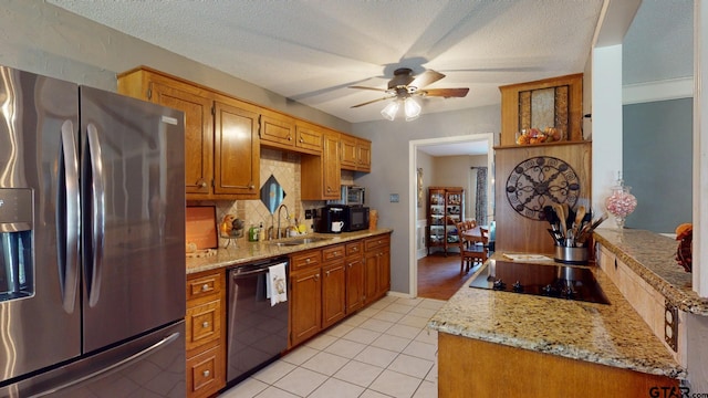 kitchen with ceiling fan, a textured ceiling, black appliances, and light stone counters