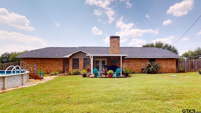 back of house with a patio and a yard