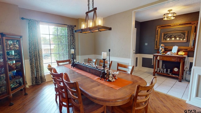 dining room with light hardwood / wood-style floors and a textured ceiling