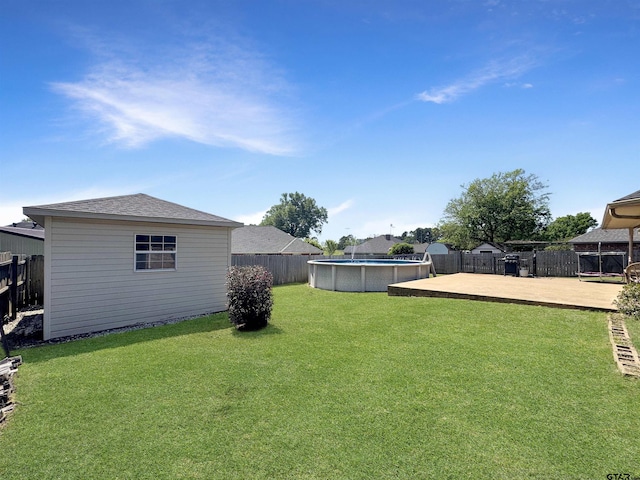 view of yard featuring an outdoor structure, a fenced in pool, and a fenced backyard