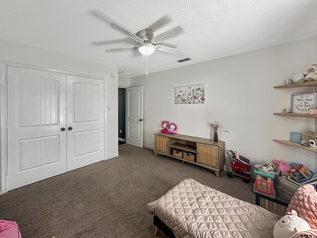 bedroom featuring a textured ceiling, visible vents, carpet, a ceiling fan, and a closet