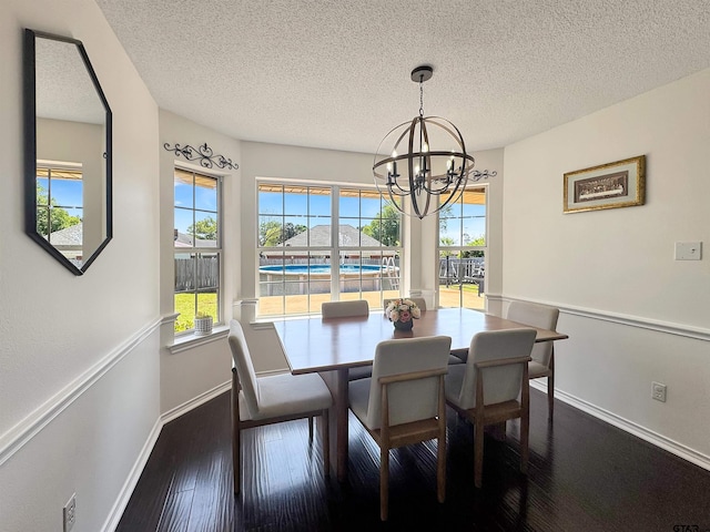 dining room featuring hardwood / wood-style flooring, baseboards, an inviting chandelier, and a textured ceiling
