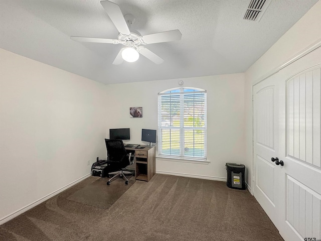 carpeted home office featuring baseboards, visible vents, a textured ceiling, and ceiling fan
